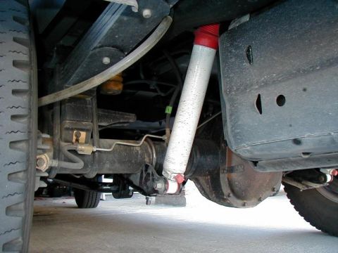 2002 Ford Excursion - The rear suspension of a 2002 Ford Excursion shows leaf springs and a shock absorber.