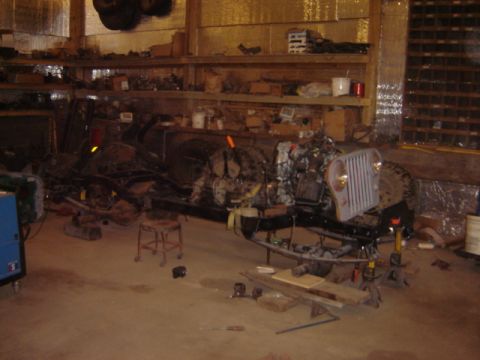 1992 Ford Bronco - Jeep CJ frame and engine assembly undergoing work in a garage setting.