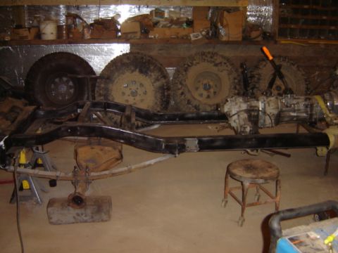 1992 Ford Bronco - The chassis and drivetrain components are laid out in a workshop setting, awaiting assembly or repair.