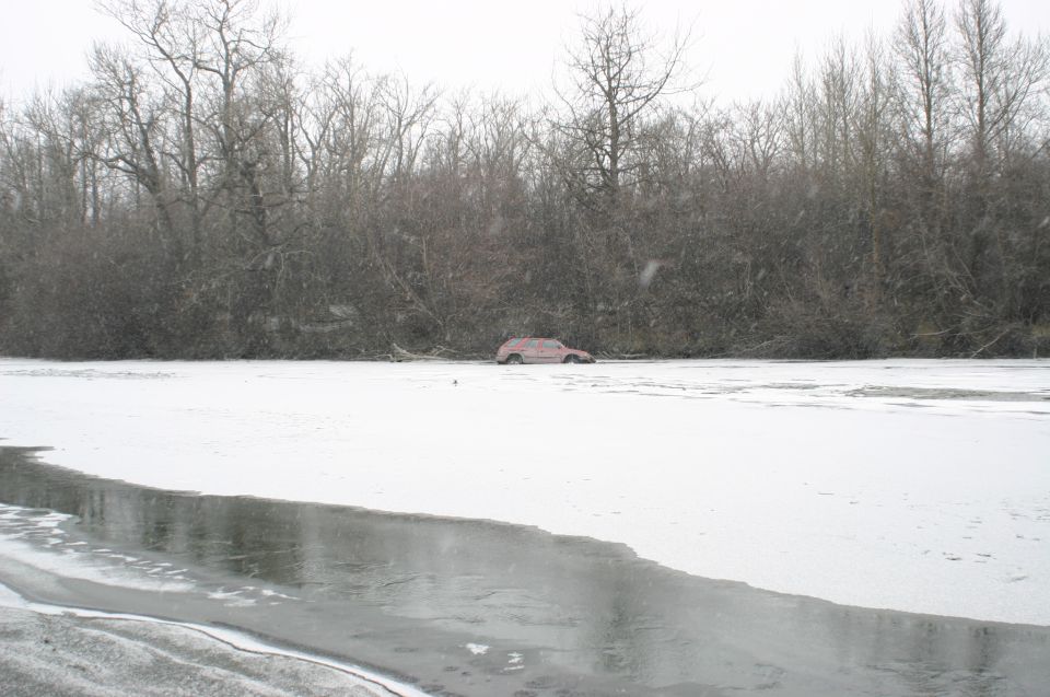 red SUV stuck in ice near bare trees