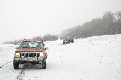 2003 Jeep TJ - A convoy of Jeeps and trucks navigate a snowy landscape during a winter outing.