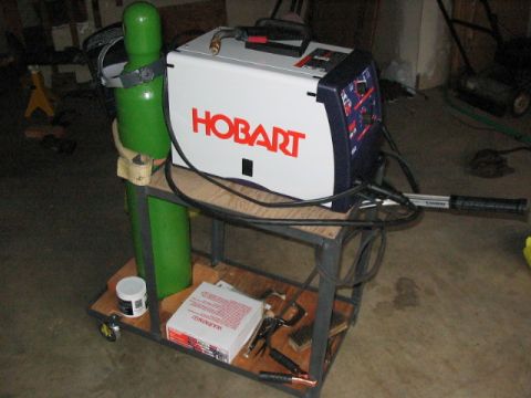 1995 Ford Bronco - A Hobart welding machine is set up on a cart with a gas cylinder and various welding accessories.