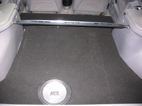 1994 Ford Probe - Subwoofer installed in the trunk of a car, with a strut bar visible above.