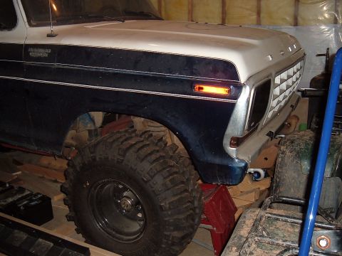 1979 Ford Bronco - A blue and white 1978 Ford Bronco is shown with large tires, supported by red jack stands in a garage.