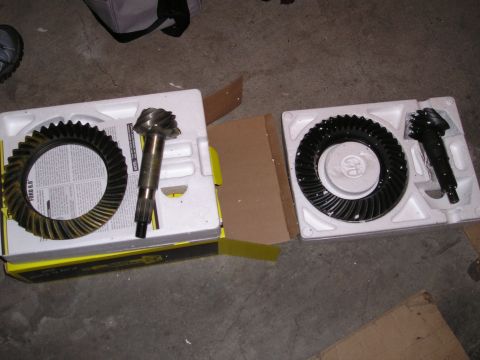 1989 Ford Bronco - Two new sets of differential gears are laid out on a concrete floor, ready for installation.