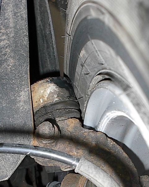 1985 Mercury Grand Marquis - A close-up view of a vehicle's suspension system and tire, showing some rust on the metal components.