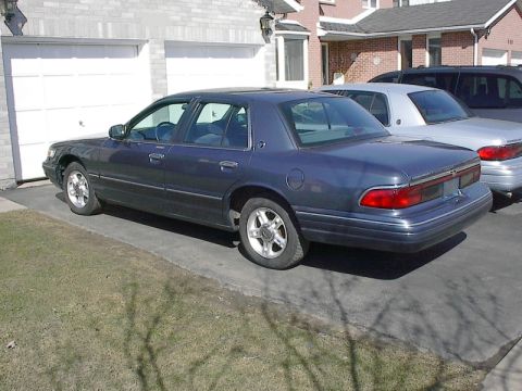 1985 Mercury Grand Marquis - This dark blue 1996 Mercury Grand Marquis is parked in a driveway next to other vehicles.