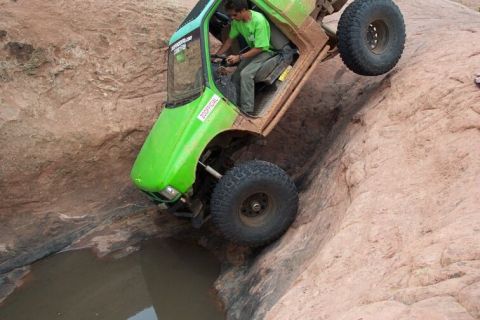 1990 Ford Bronco - This heavily modified off-road vehicle is attempting to traverse a challenging rocky obstacle.