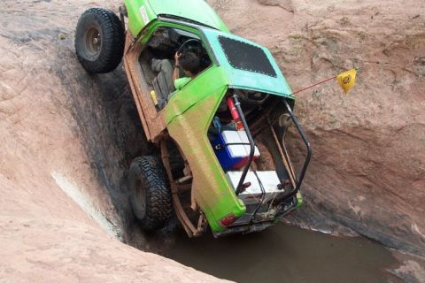 1990 Ford Bronco - This heavily modified off-road vehicle navigates a challenging rocky terrain.