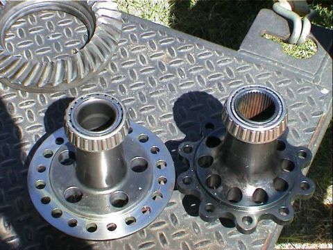 1979 Ford Bronco - Two differential components, a ring gear and a pinion gear with bearings, are displayed on a metal surface.