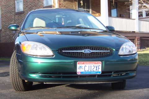 2000 Ford Taurus - Front view of a green 2000 Ford Taurus sedan parked outside a house.