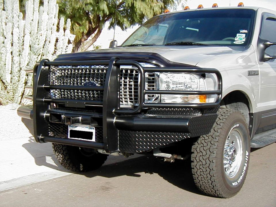Silver Ford SUV with black brush guard and diamond-plate bumper, front 3/4 view