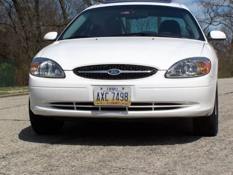 2001 Ford Taurus - Front view of a white 2001 Ford Taurus, showing its grille and headlights. The Ohio license plate reads AXC 7498.