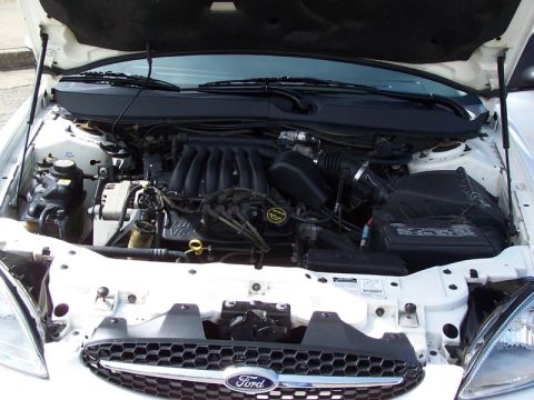 2001 Ford Taurus - Engine compartment of a 2001 Ford Taurus, showing the V6 engine and associated components.