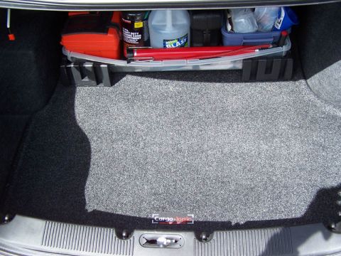 2001 Ford Taurus - The trunk of a car contains various items, including a toolbox and cleaning supplies, organized in a plastic container.