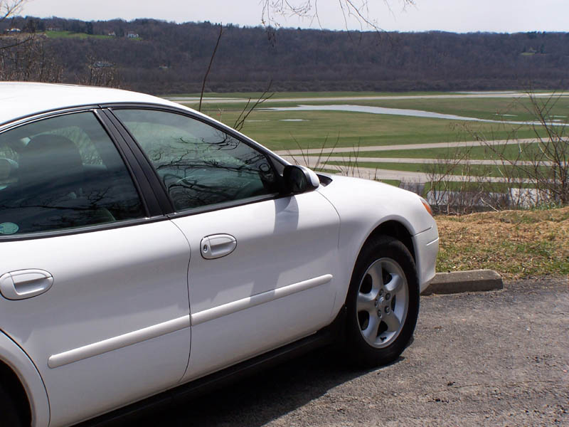 White sedan parked on asphalt with a body style consistent with early 2000s models
