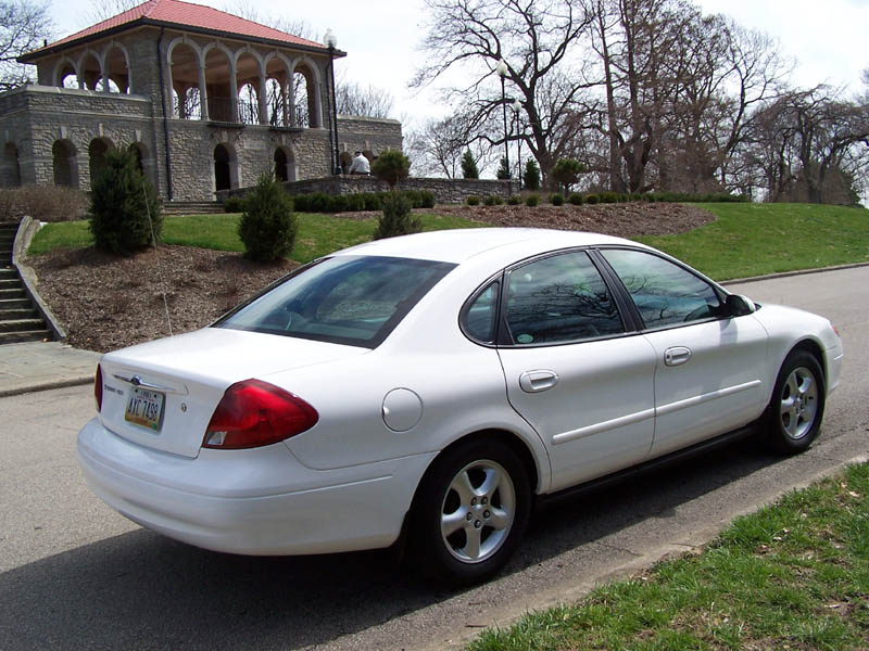 White 2001 Ford Taurus rear view parked on street with building in background