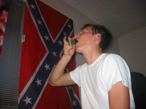 1989 Ford Bronco - Man drinks from a can with a Confederate flag hanging behind him.