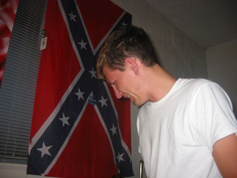 1989 Ford Bronco - A man stands in front of a confederate flag, with a watermark for SuperMotors.net visible.
