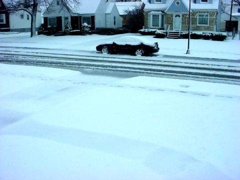 1973 Ford Ranchero - A car sits on a snow-covered street in front of residential homes.