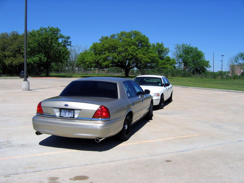Gold 2000 Ford Crown Victoria, rear 3/4 view, parked in lot