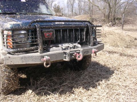 1995 Jeep Cherokee - Muddy Jeep Cherokee XJ front view, showing winch and grille. Likely a 1997-2001 model.