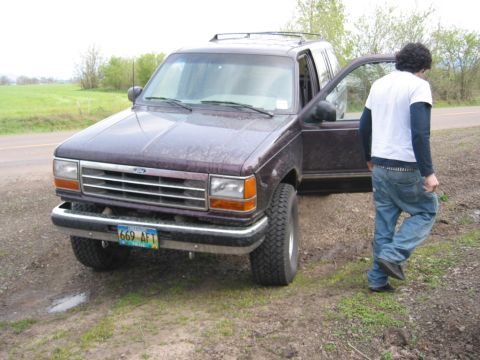 1991 Ford Explorer - A man exits a 1991 Ford Explorer parked on the side of a dirt road.