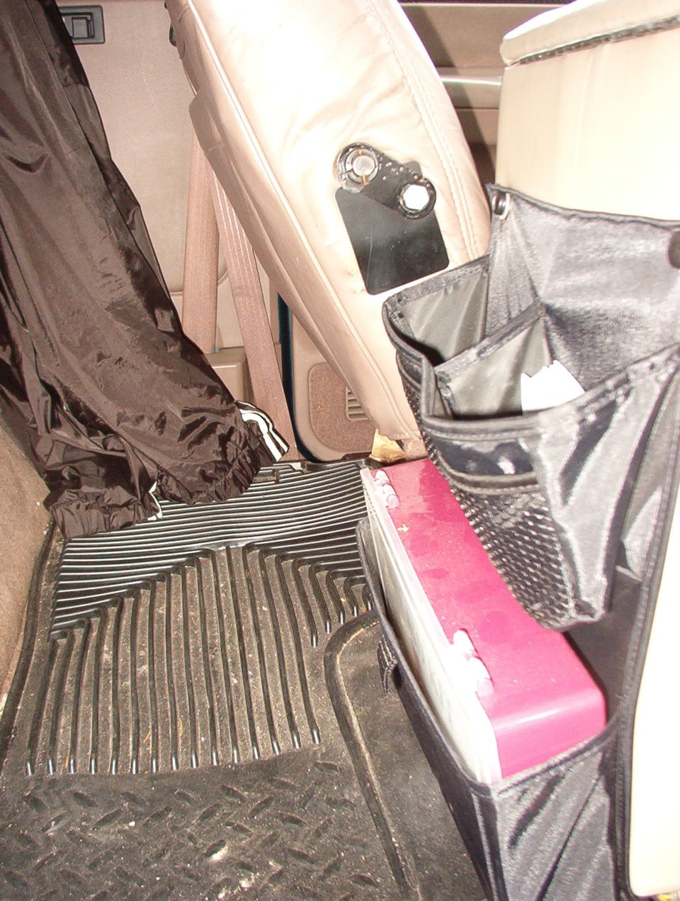 SUV rear floor with rubber mat, seat-back organizer, and pink storage case