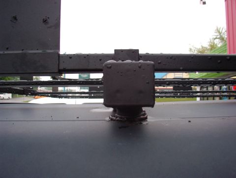 1993 Ford Bronco - Close-up of a roof rack mount on a 1993 Ford Bronco, showing water droplets on the metal.