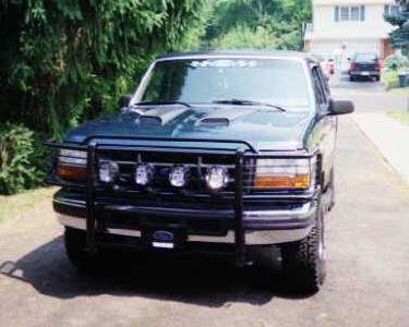 1993 Ford Bronco - Front view of a dark green 1993 Ford Bronco parked on a paved driveway.