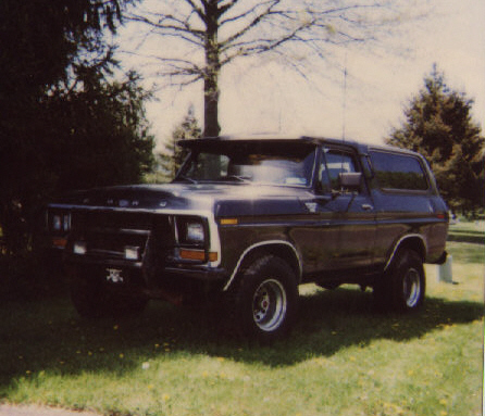 1993 Ford Bronco - This Ford Bronco is parked outdoors on a grassy area with trees surrounding it.