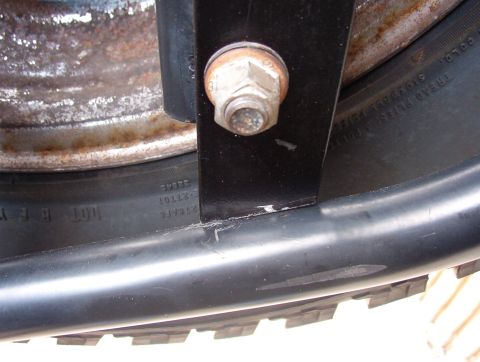 1993 Ford Bronco - Detail of a spare tire and its mounting hardware, showing a bolt and bracket.
