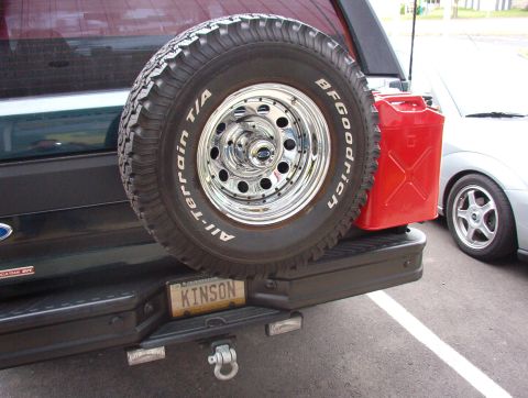 1993 Ford Bronco - Rear view of an SUV with a spare tire and a red jerry can mounted on the back.