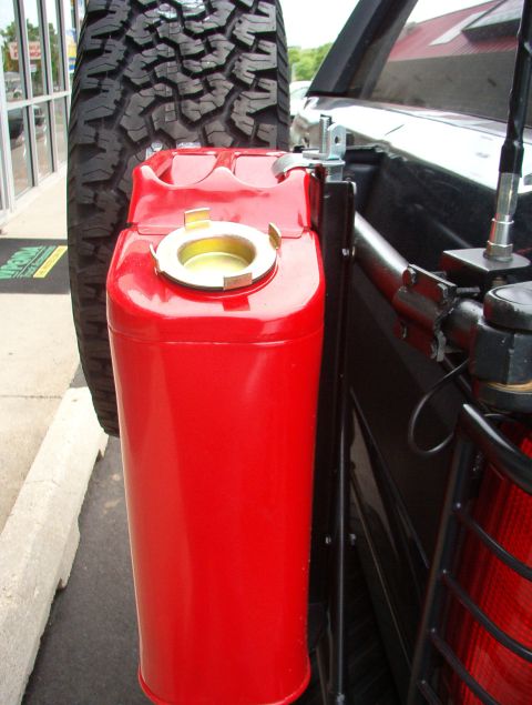 1993 Ford Bronco - A red jerry can is mounted to the side of a vehicle, with a tire in the background.