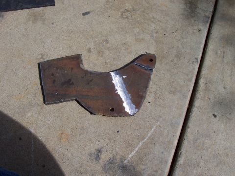 1994 Ford F-150 - A fabricated metal bracket, likely for automotive use, rests on a concrete floor.