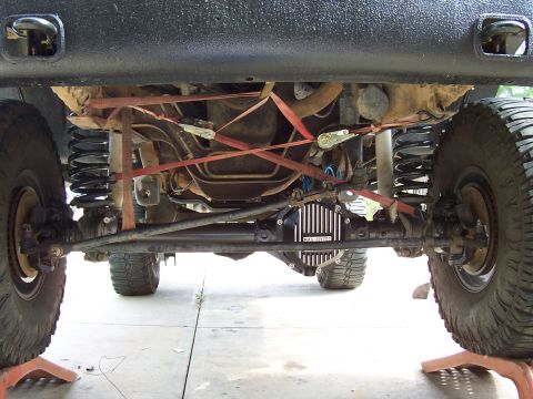 1994 Ford F-150 - The underside of a vehicle is shown, focusing on the front axle, suspension, and a Mag-Hytec differential cover.
