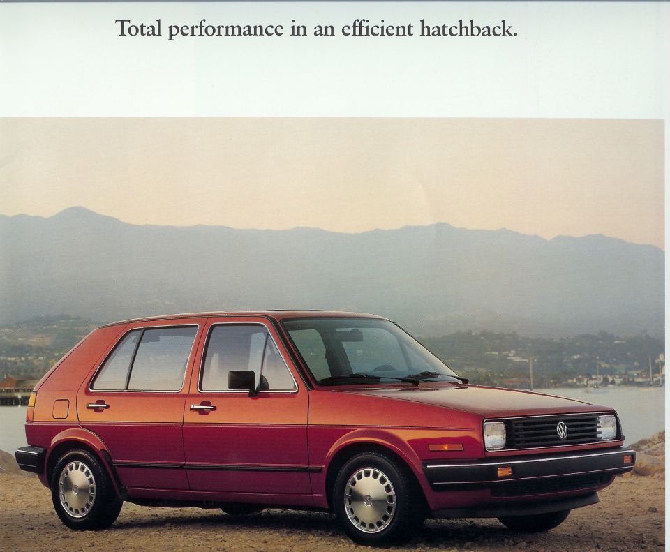 Red 1987 Volkswagen Golf hatchback parked outdoors with mountains in background