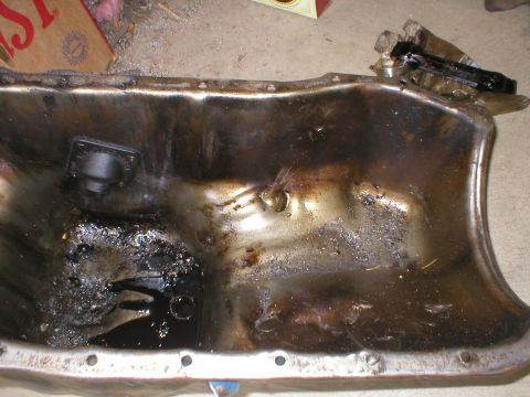 1978 Ford Bronco - This image shows a used oil pan, likely removed from an engine for inspection or repair.