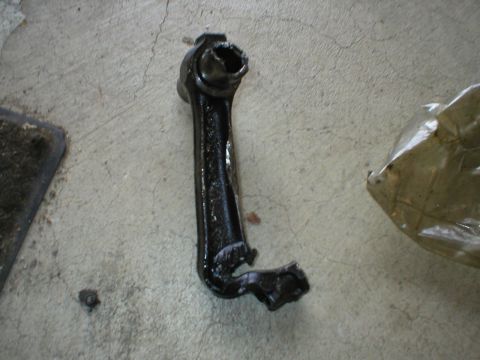 1978 Ford Bronco - A damaged connecting rod lies on a concrete surface next to a plastic-wrapped object.