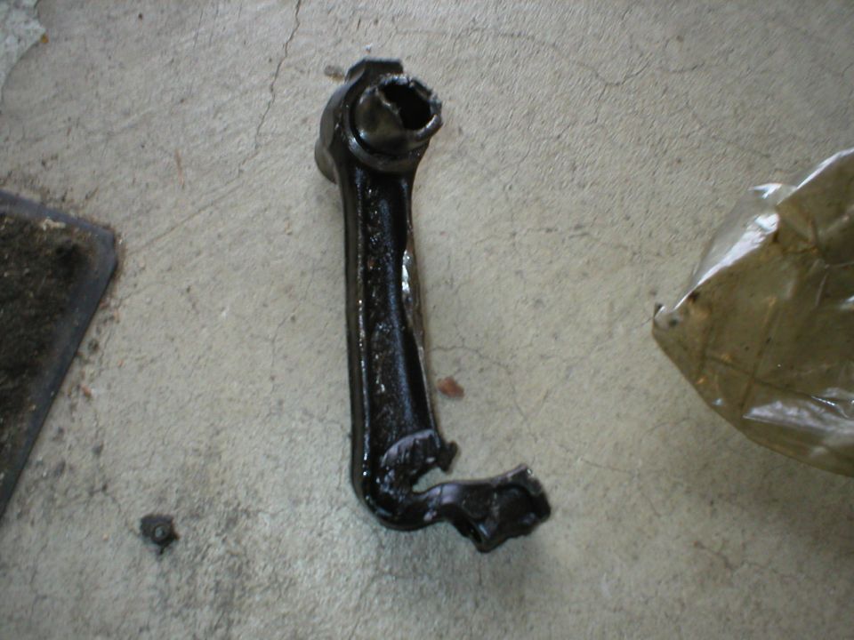 Black connecting rod with damaged end on concrete