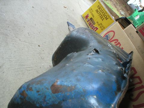 1978 Ford Bronco - Close-up of a damaged blue oil pan, likely from an older vehicle.