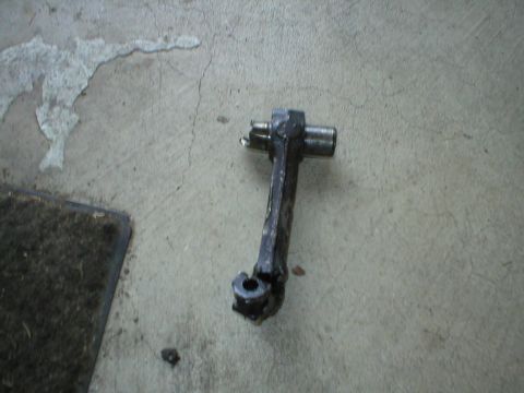 1978 Ford Bronco - A close-up view of a metal automotive component resting on a concrete surface.