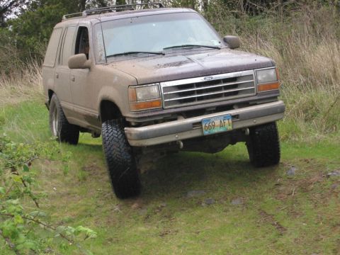 1991 Ford Explorer - A muddy 1991 Ford Explorer navigates an off-road trail, its capabilities.
