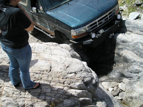 1993 Ford Bronco - Ford Bronco tackling difficult terrain on a rocky off-road path.