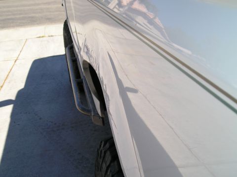 1993 Ford Bronco - A white 1993 Ford Bronco is shown from the side, aftermarket side steps and subtle pinstriping along the body.