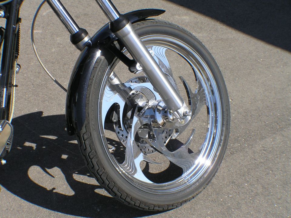 Polished billet swept-spoke motorcycle front wheel with matching floating brake rotor
