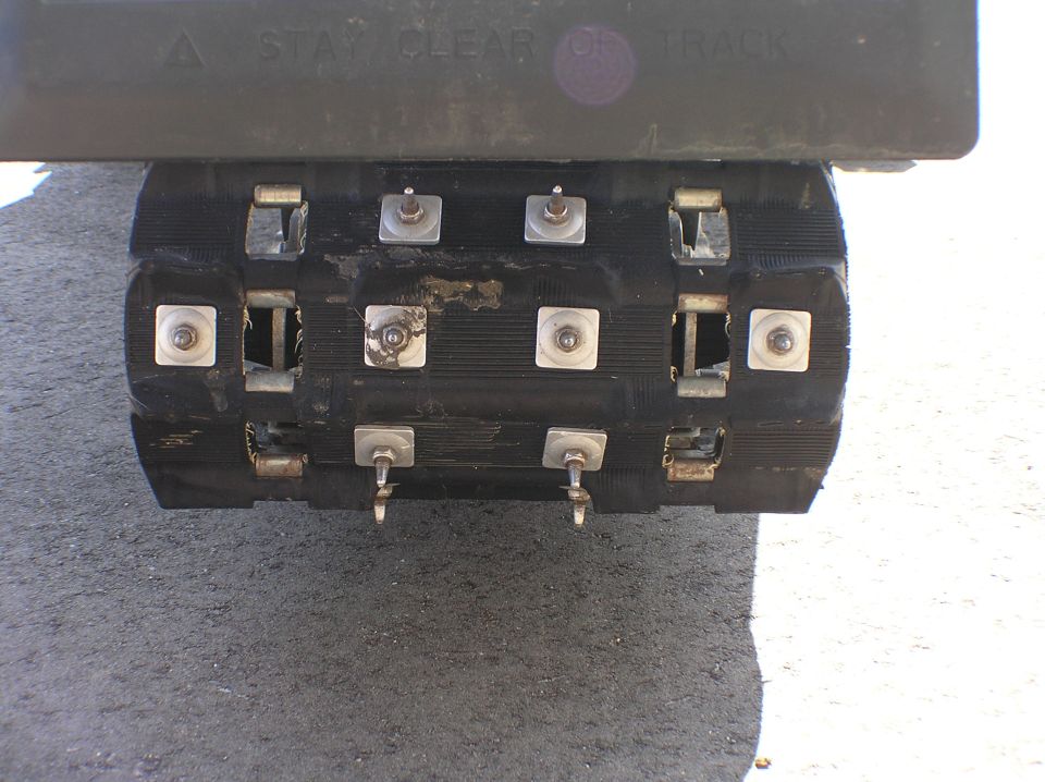 Rubber track unit on trailer marked STAY CLEAR OF TRACK on tailgate