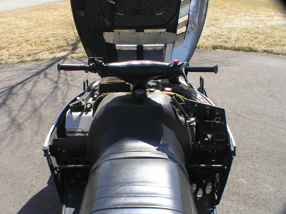 Rear view of black Polaris snowmobile seat and handlebars on pavement
