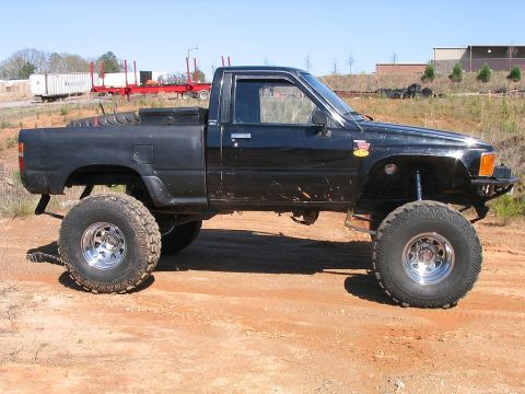 1986 Ford F-150 - This modified pickup truck features oversized tires and a lifted suspension, giving it an aggressive stance.