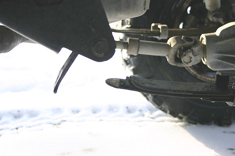 Undercarriage detail showing bent leaf spring and driveshaft